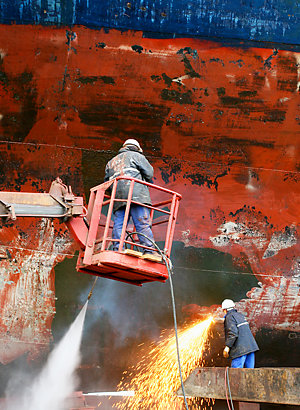 Wet scraping process made with high pressure water to clean the surface of the ship before the painting process.